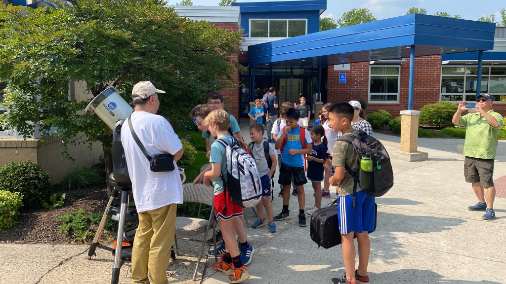 Renjiang Xie introducing a solar telescope to children at Haycock Elementary School