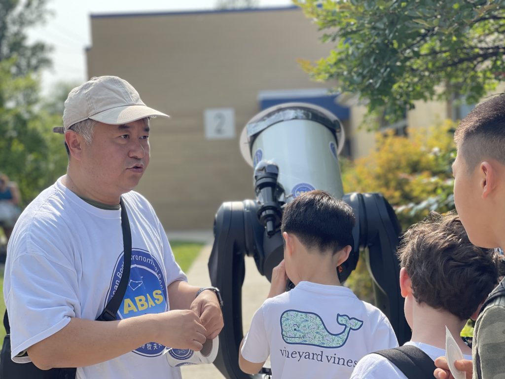 Renjiang Xie guiding a child to observe the Sun safely