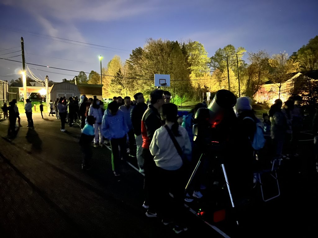 Visitors gathered near the basketball courts for sidewalk astronomy at Longfellow Middle School