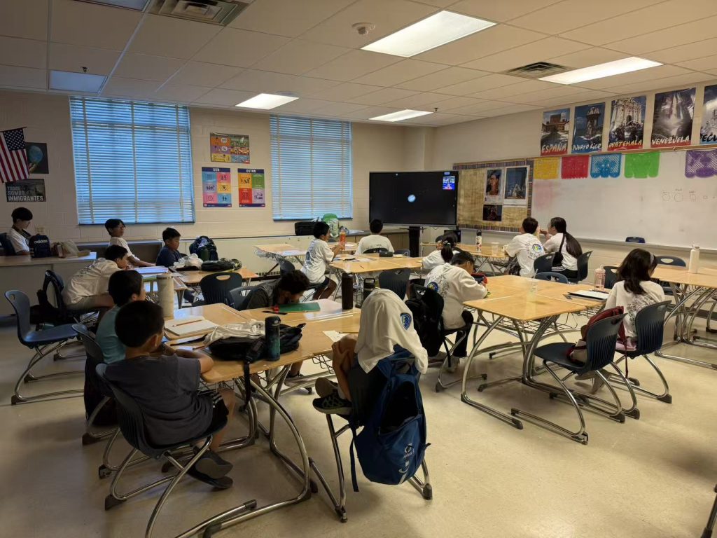 Campers watching a guest astronomy lecture shown on a classroom screen