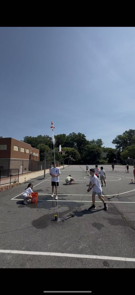 Campers launching a water rocket on the school grounds