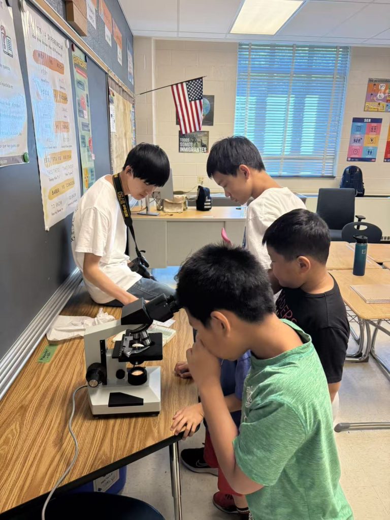 Campers taking turns at a microscope