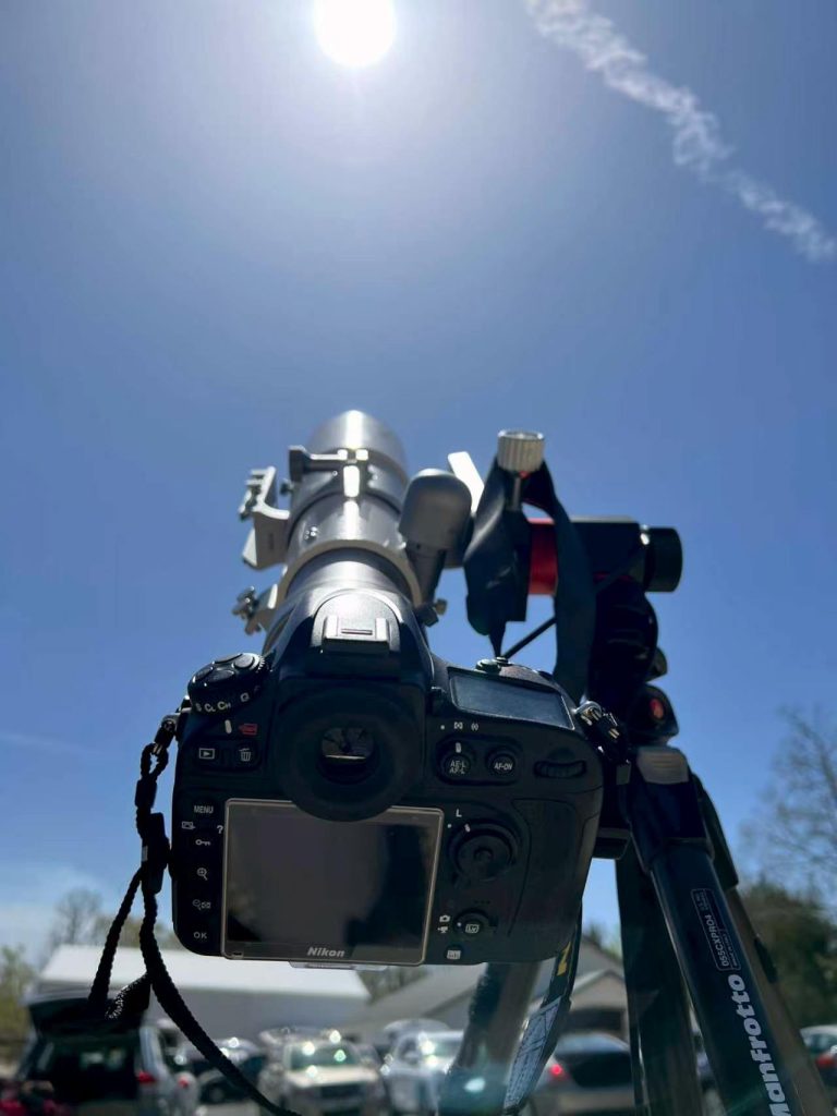 A second telescope-and-camera setup on a tripod, with a shutter-release cable hanging down