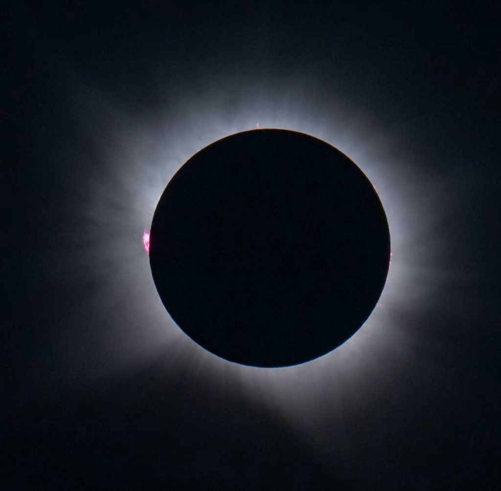 The total solar eclipse in Lerma, with the corona around the Moon’s dark silhouette and red prominences at the edge