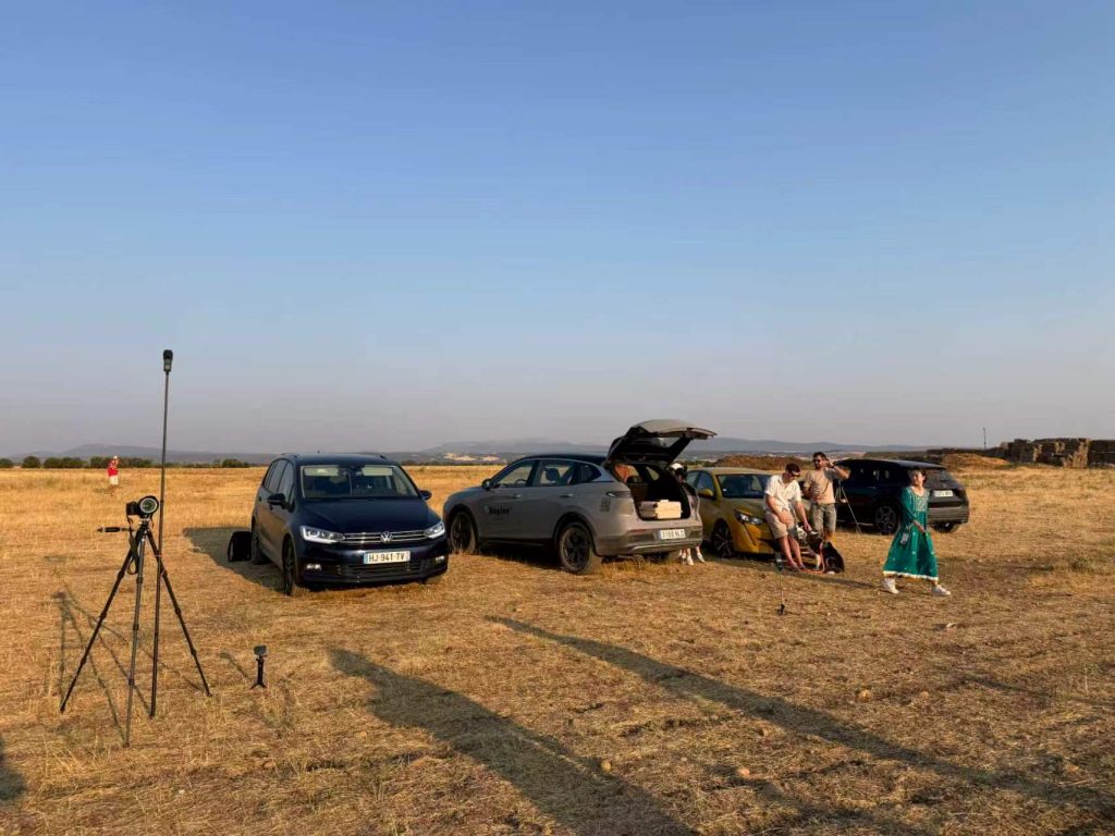 Cars parked on the grass at the Lerma observing site, with tripods, cameras, and team members around them